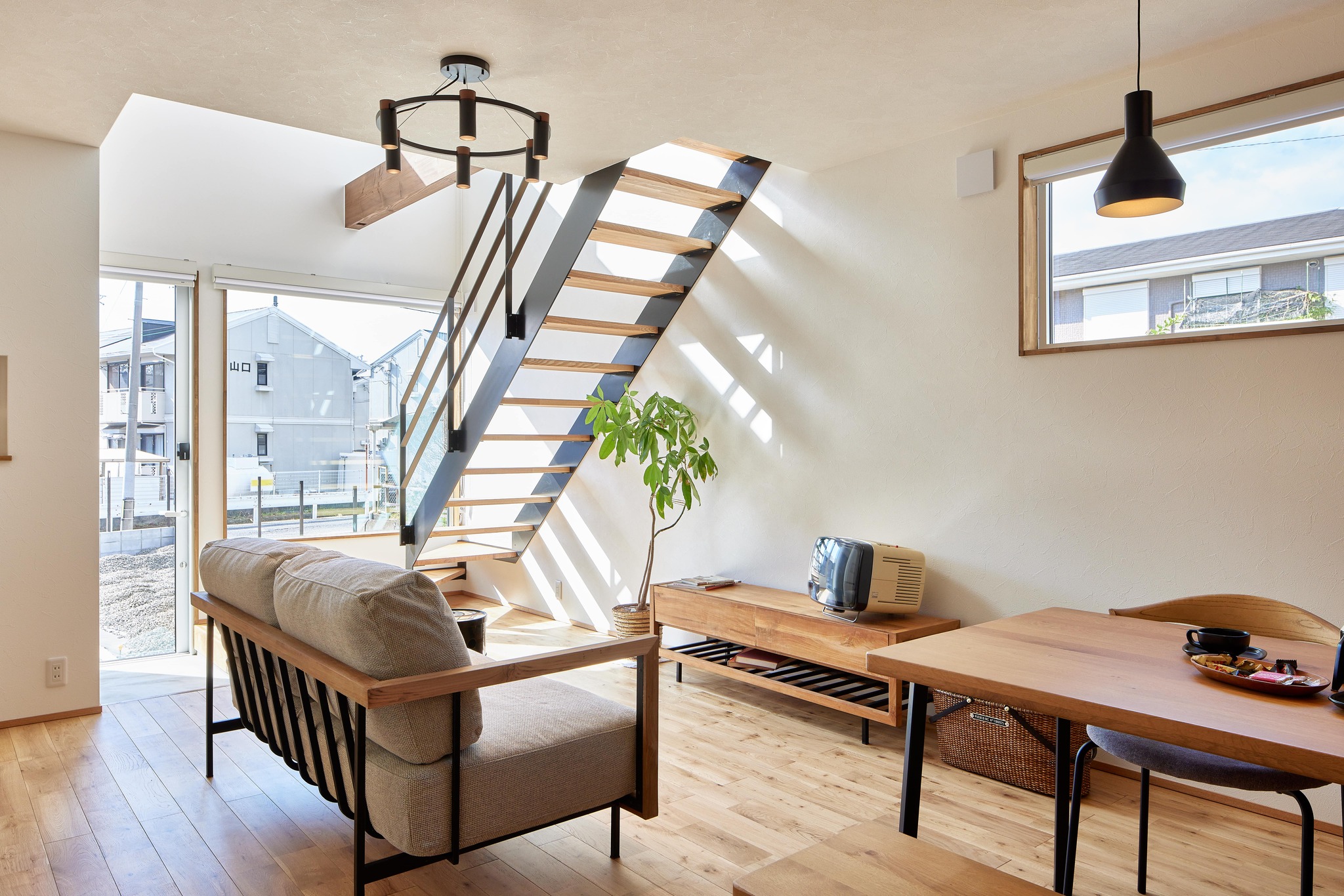 吹き抜けと大きな窓で光が入る明るいリビング空間