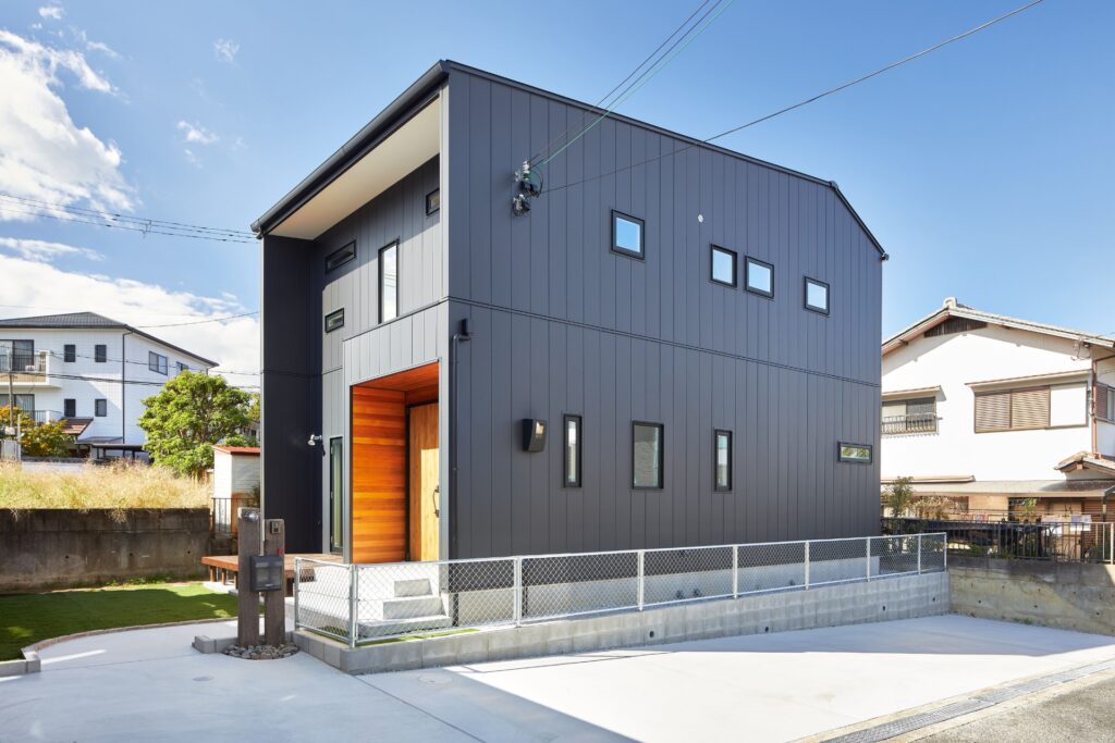 熊取町に建つ黒いガルバリウム外壁と木の玄関が印象的な注文住宅